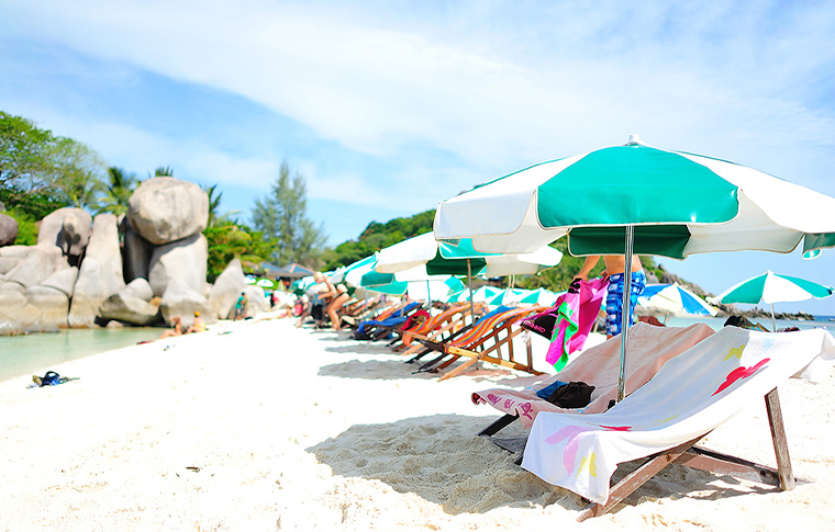 Row of chairs and umbrellas on the white sandy beach